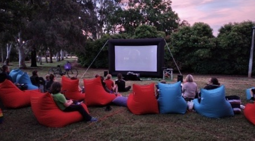 Outdoor movie night with the community gathered on beanbag chairs